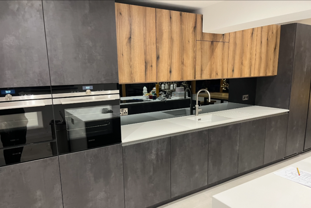 A contemporary kitchen featuring wooden cabinets paired with sleek black appliances, showcasing a stylish and functional design.