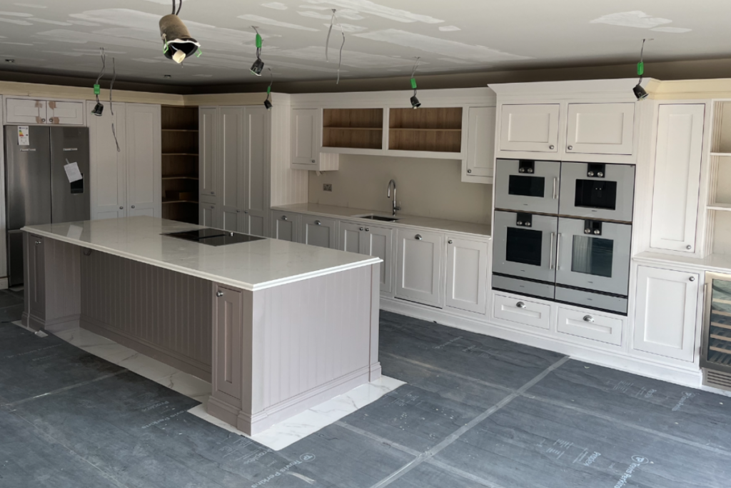 A modern kitchen featuring white cabinets and a spacious central island, creating an inviting cooking space.