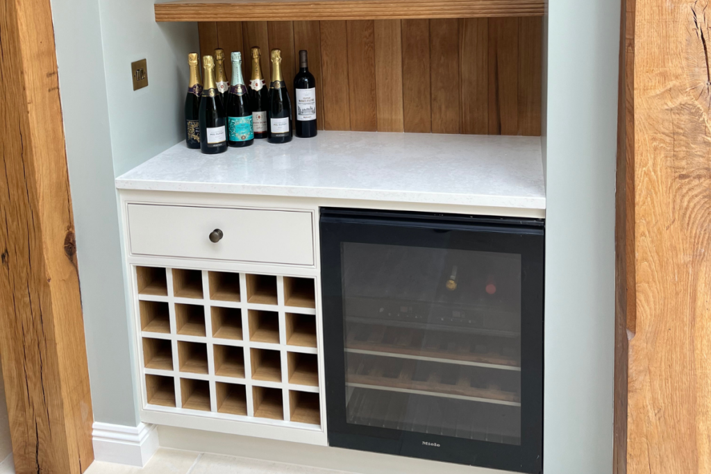 A sleek wine cooler sits in a modern kitchen, surrounded by shelves filled with various kitchen items and decor.