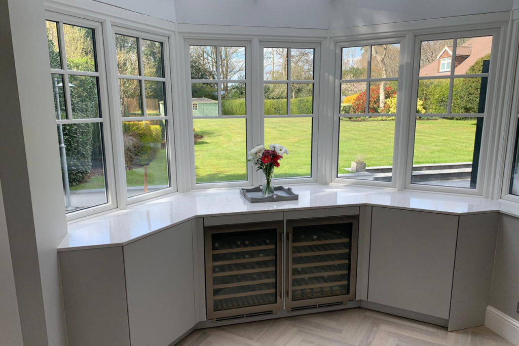 A cozy corner kitchen featuring a wine rack and a bright window, creating a warm and inviting atmosphere.