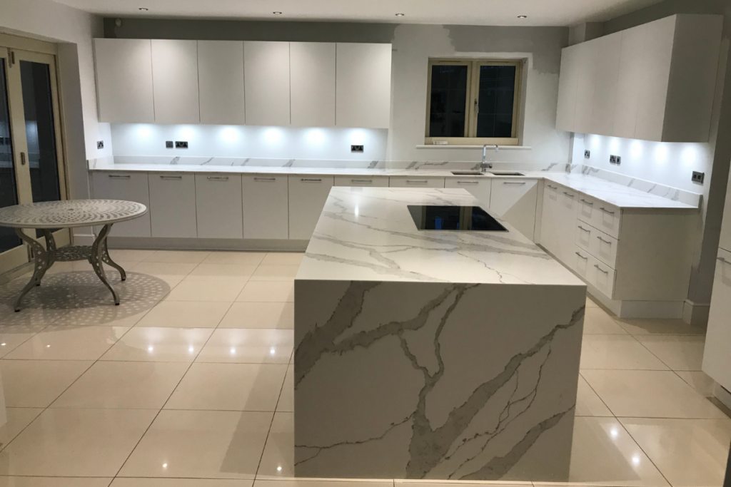 A modern kitchen featuring elegant marble countertops and sleek white cabinets, creating a bright and stylish atmosphere.