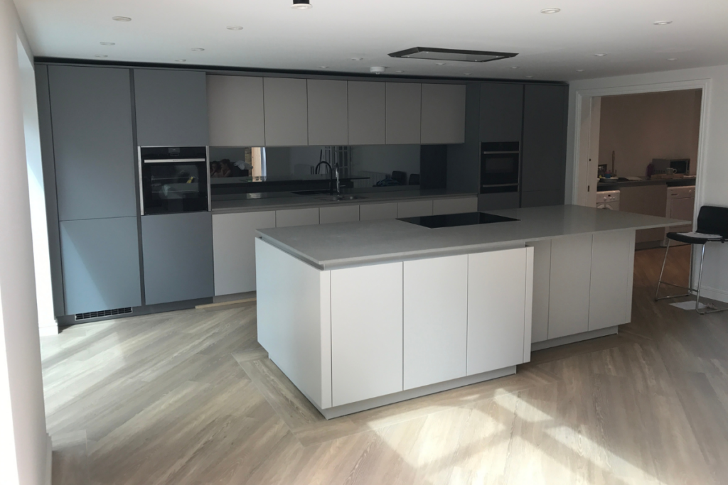 A modern kitchen featuring sleek grey cabinets and a spacious central island for cooking and gathering.