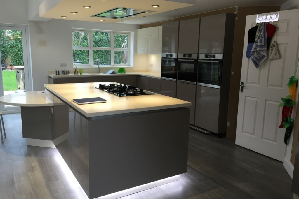 A sleek modern kitchen featuring a spacious island with a sink, showcasing contemporary design and functionality.