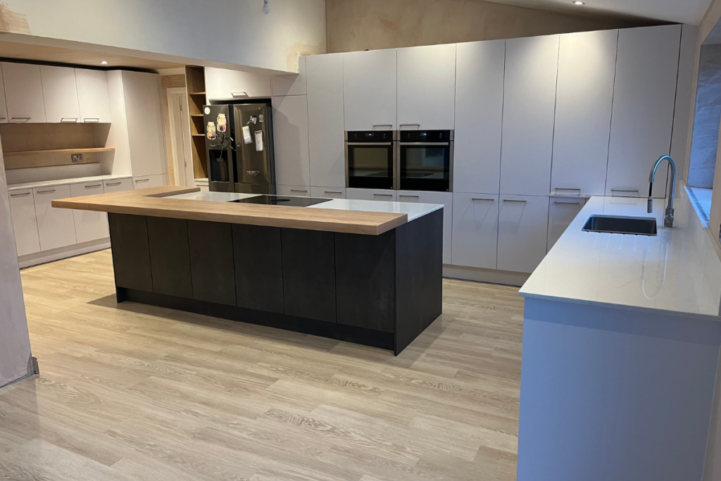 A bright kitchen featuring white cabinets and warm wooden floors, creating a cozy and inviting atmosphere.