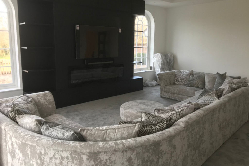 A cozy living room featuring a comfortable couch and a flat-screen television on the wall.