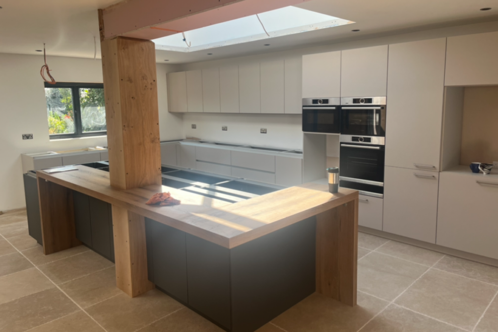 A bright kitchen featuring a skylight and a spacious wooden island, creating a warm and inviting atmosphere.