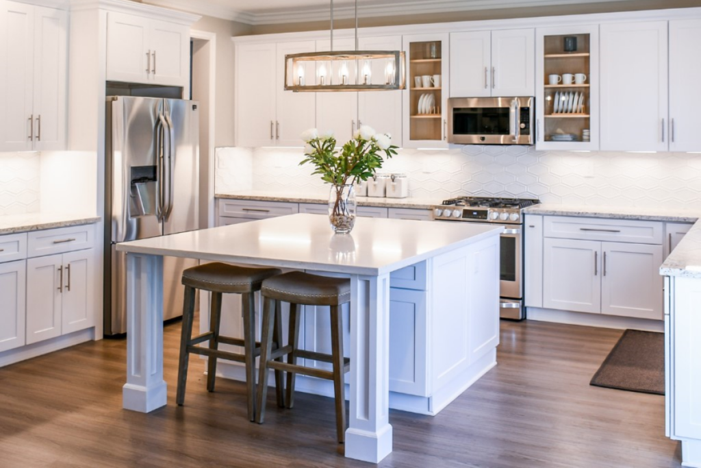 A bright kitchen featuring white cabinets and a spacious center island, showcasing a clean and modern design.